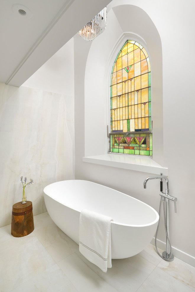 Immagine di una stanza da bagno contemporanea con vasca freestanding, pareti bianche e pavimento bianco