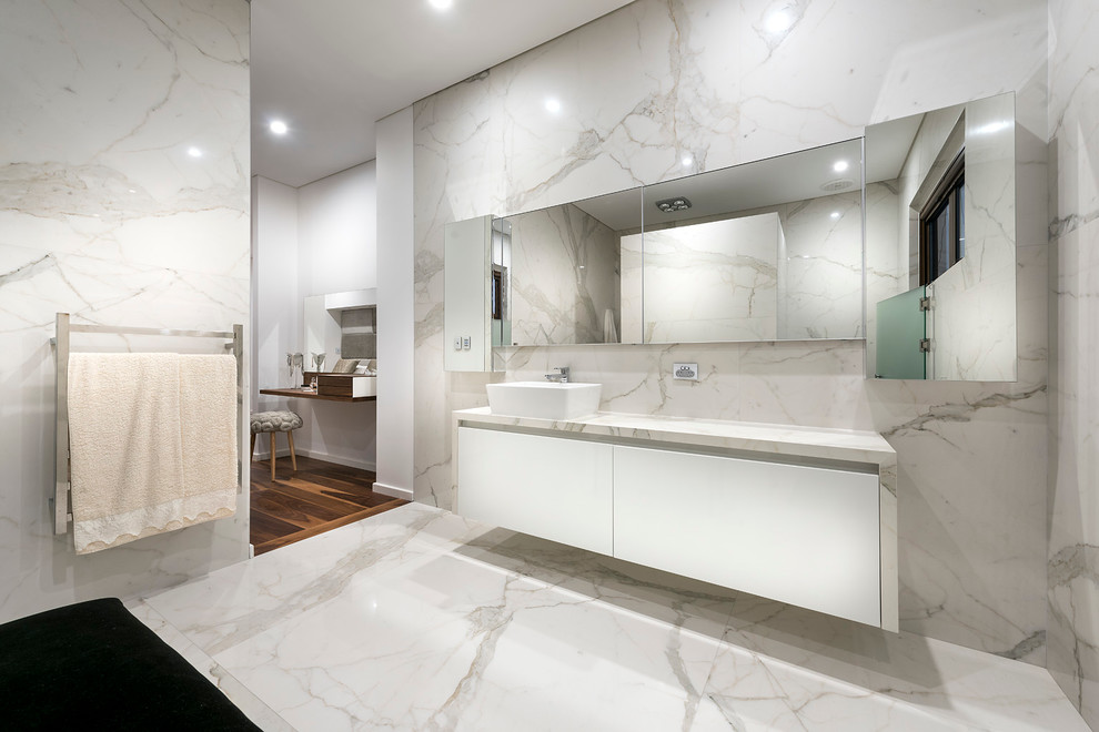 Inredning av ett modernt mellanstort en-suite badrum, med ett fristående handfat, vita skåp, marmorbänkskiva, en öppen dusch, vit kakel, porslinskakel, vita väggar och kalkstensgolv