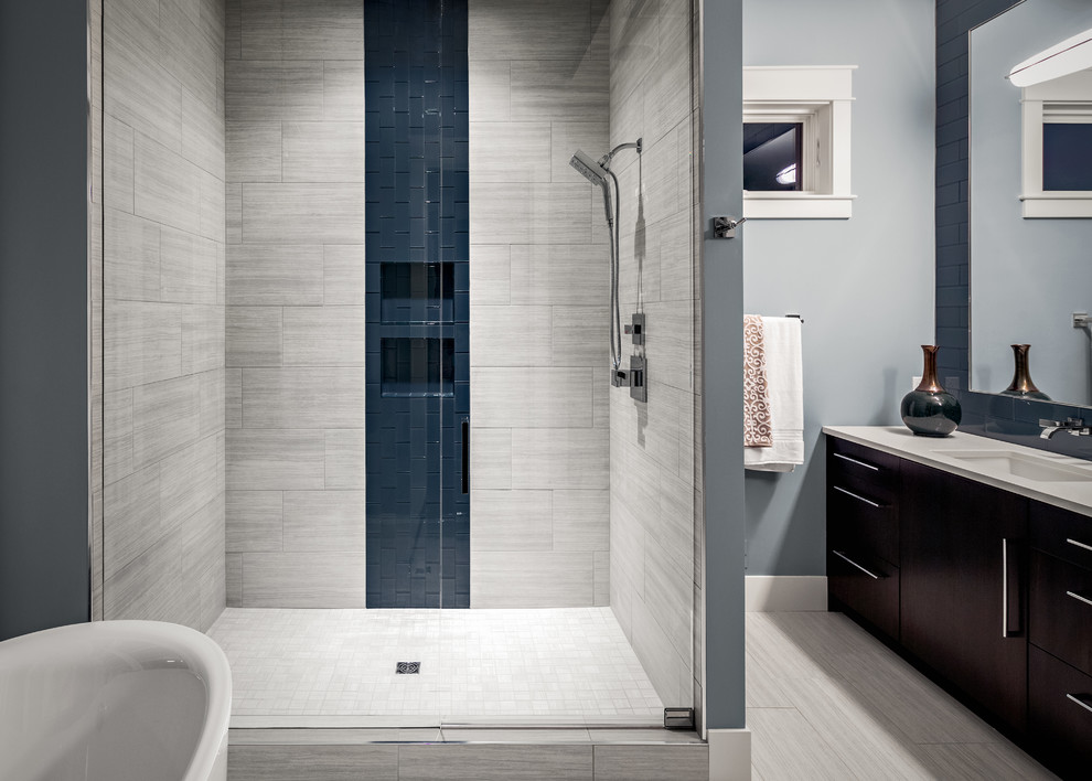 Large classic ensuite bathroom in Grand Rapids with flat-panel cabinets, dark wood cabinets, a freestanding bath, an alcove shower, a two-piece toilet, white tiles, grey walls, travertine flooring, a submerged sink and concrete worktops.