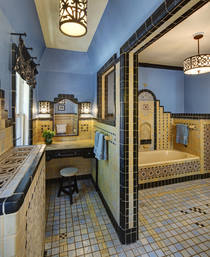 Inspiration for a mediterranean bathroom in Milwaukee with an alcove bath, multi-coloured tiles and porcelain flooring.
