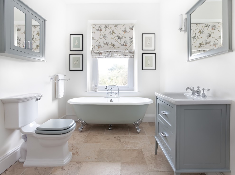 Inspiration for a medium sized classic bathroom in Gloucestershire with shaker cabinets, grey cabinets, a one-piece toilet, ceramic tiles, white walls, limestone flooring, a claw-foot bath, beige tiles, a console sink and beige floors.