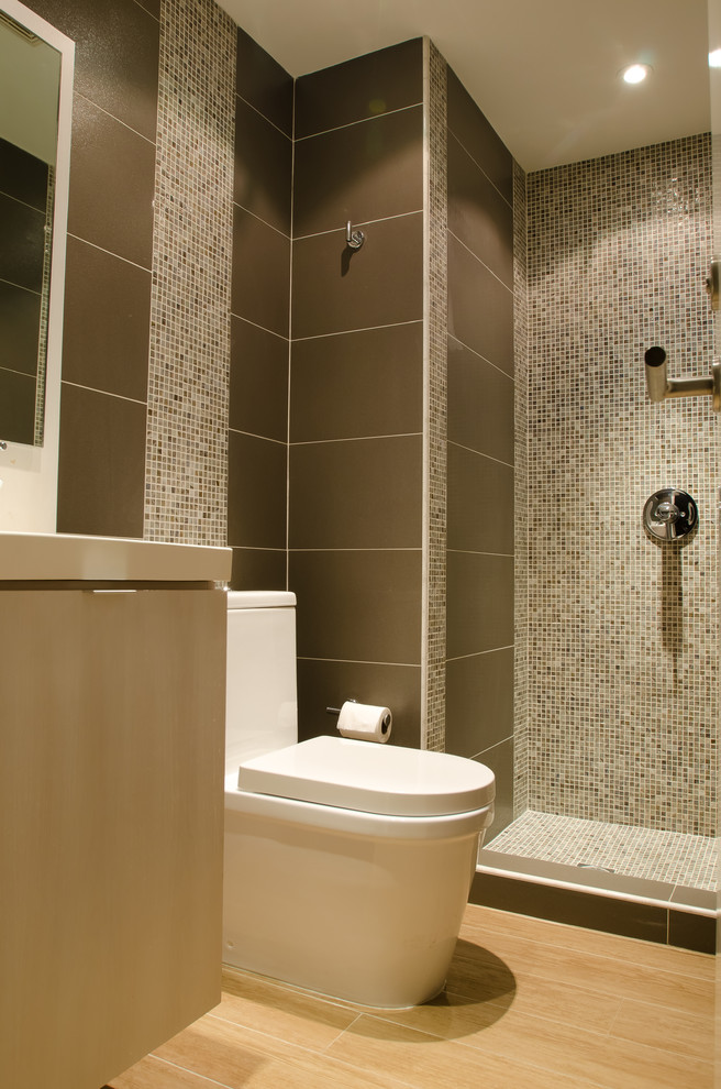 Exempel på ett litet modernt badrum med dusch, med släta luckor, skåp i ljust trä, bänkskiva i akrylsten, brun kakel, keramikplattor, en dusch i en alkov, en toalettstol med hel cisternkåpa, ett integrerad handfat, bruna väggar och klinkergolv i keramik