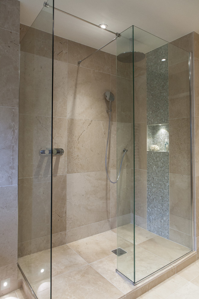 Exempel på ett mellanstort modernt en-suite badrum, med släta luckor, skåp i mörkt trä, en öppen dusch, en vägghängd toalettstol, beige kakel, kakelplattor, beige väggar, kalkstensgolv, ett väggmonterat handfat, bänkskiva i akrylsten, beiget golv och med dusch som är öppen