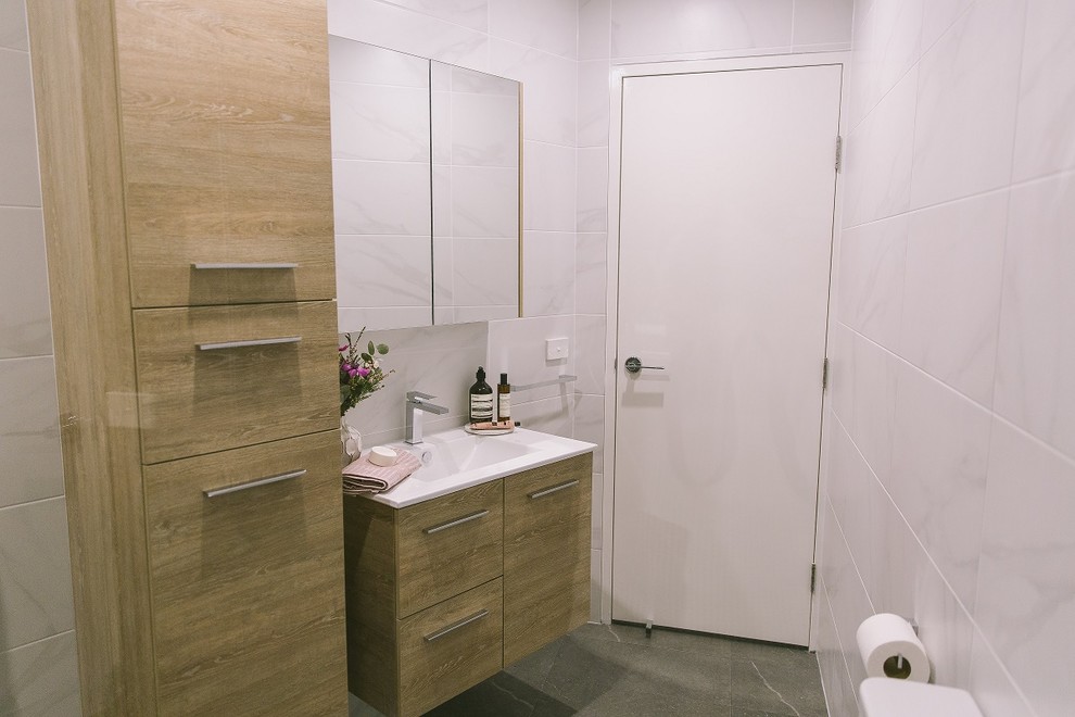 Immagine di una piccola stanza da bagno con doccia moderna con consolle stile comò, ante in legno chiaro, piastrelle in gres porcellanato, pavimento in gres porcellanato e pavimento grigio
