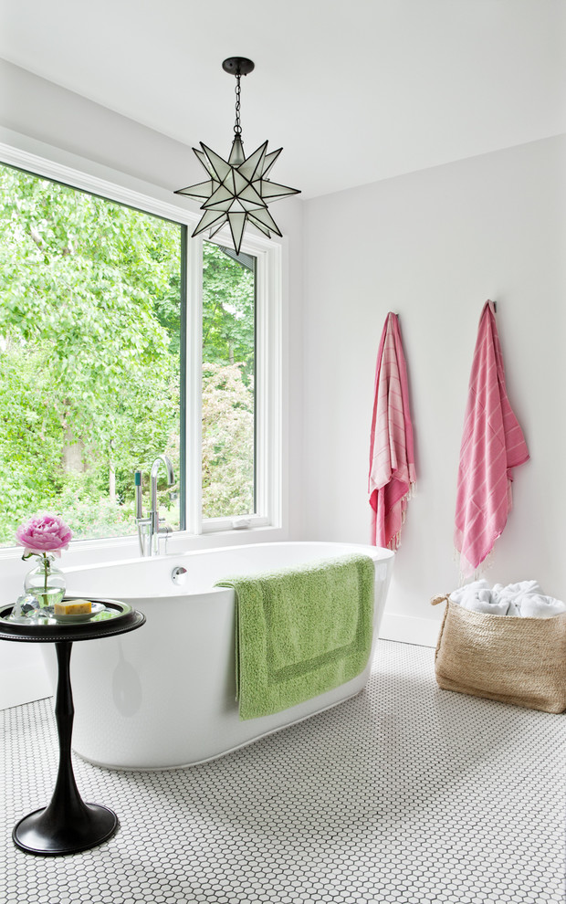 На фото: главная ванная комната в современном стиле с отдельно стоящей ванной, белыми стенами и полом из мозаичной плитки с