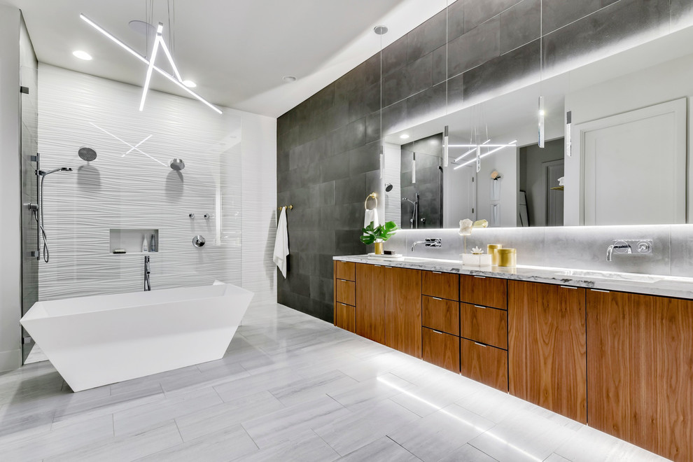 Example of a trendy master gray tile and white tile white floor bathroom design in Austin with flat-panel cabinets, medium tone wood cabinets, marble countertops and gray countertops