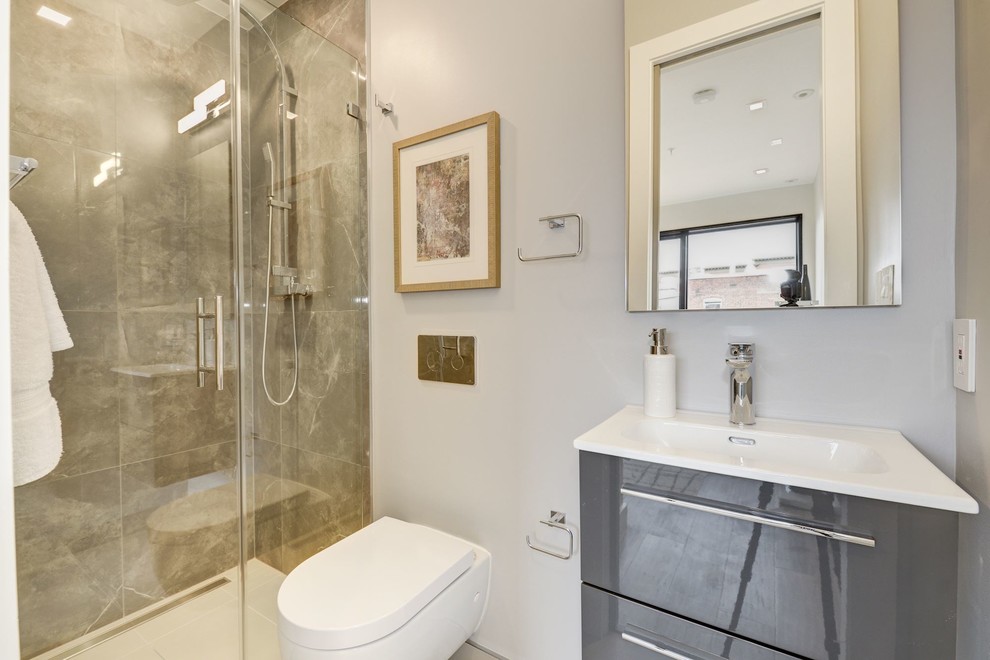 Immagine di una piccola stanza da bagno moderna con doccia a filo pavimento, WC sospeso, piastrelle in gres porcellanato, pavimento in gres porcellanato, piastrelle grigie e pavimento grigio