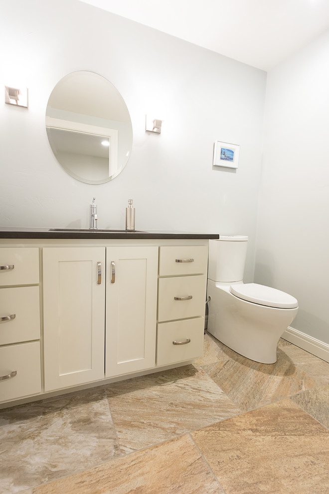 Immagine di una stanza da bagno tradizionale di medie dimensioni con ante in stile shaker, ante bianche, WC a due pezzi, pareti bianche, pavimento con piastrelle in ceramica e lavabo sottopiano