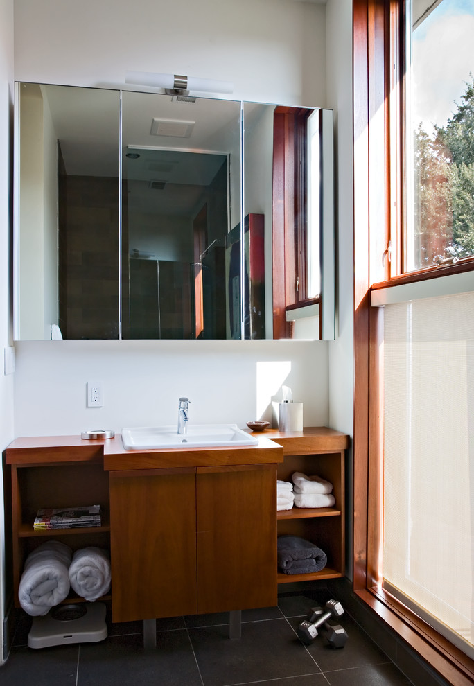 Imagen de cuarto de baño contemporáneo con lavabo encastrado, armarios abiertos, puertas de armario de madera oscura y baldosas y/o azulejos negros