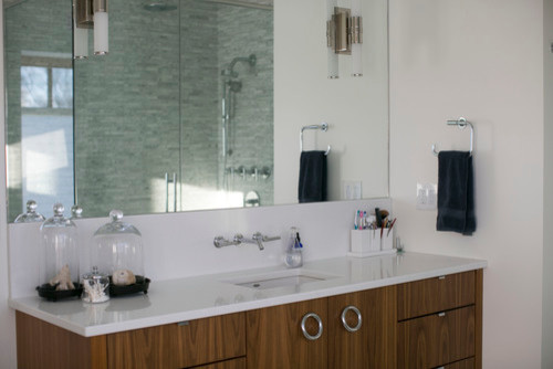 Foto di una stanza da bagno con doccia contemporanea di medie dimensioni con lavabo sottopiano, ante lisce, ante in legno scuro, top in quarzite, piastrelle bianche, pareti bianche, doccia ad angolo e piastrelle di vetro