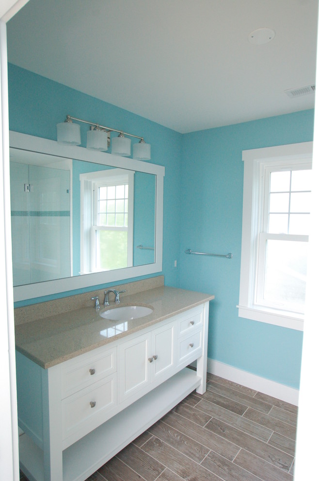 Inspiration for a medium sized coastal ensuite bathroom in DC Metro with a submerged sink, flat-panel cabinets, white cabinets, granite worktops, blue walls and porcelain flooring.