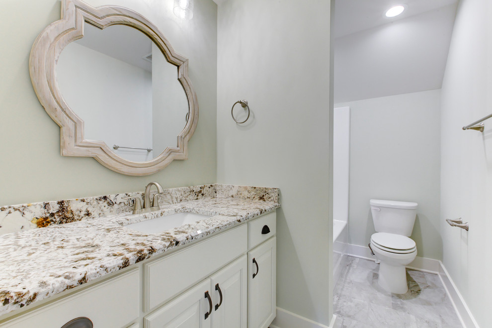 Пример оригинального дизайна: детская ванная комната среднего размера в стиле кантри с фасадами с выступающей филенкой, белыми фасадами, душем над ванной, унитазом-моноблоком, зелеными стенами, полом из керамогранита, врезной раковиной, столешницей из гранита, серым полом, шторкой для ванной и белой столешницей
