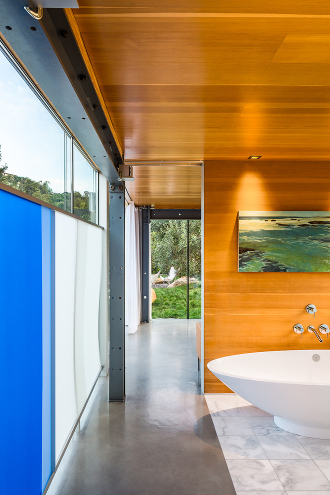 Immagine di una piccola stanza da bagno padronale contemporanea con ante in legno scuro, top in legno, vasca freestanding, piastrelle bianche e pavimento in cemento