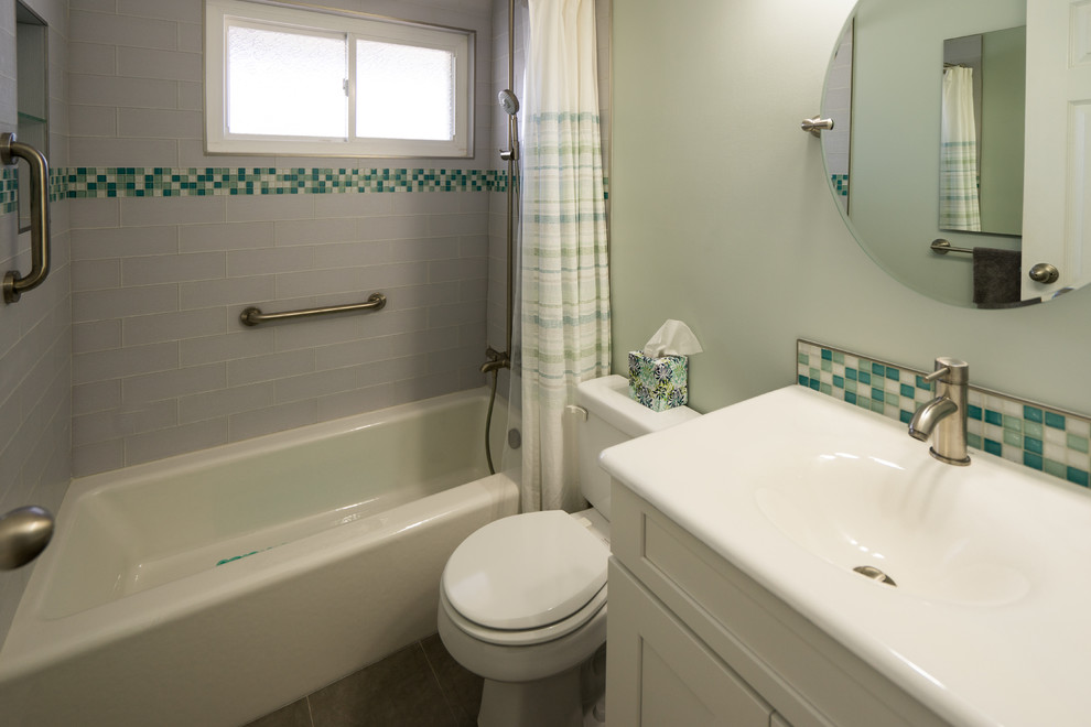 サンディエゴにあるお手頃価格の中くらいなトラディショナルスタイルのおしゃれなマスターバスルーム (落し込みパネル扉のキャビネット、白いキャビネット、ドロップイン型浴槽、分離型トイレ、白いタイル、サブウェイタイル、緑の壁、トラバーチンの床、一体型シンク、シャワー付き浴槽	、シャワーカーテン、洗面台1つ、造り付け洗面台) の写真