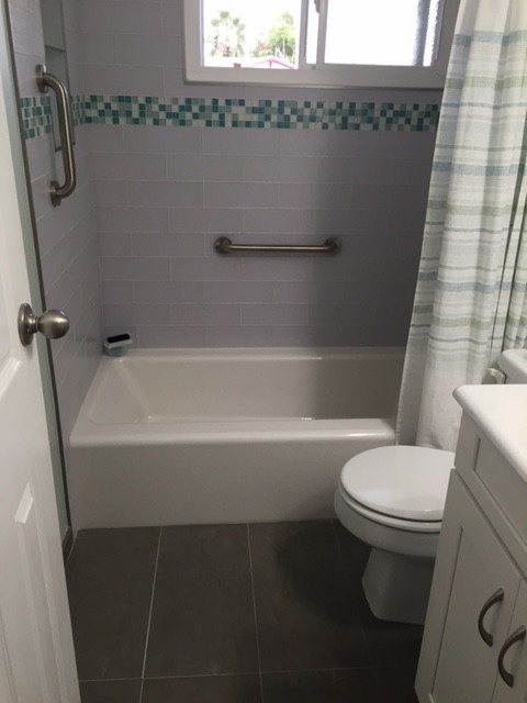 На фото: главная ванная комната среднего размера в классическом стиле с фасадами с утопленной филенкой, белыми фасадами, накладной ванной, раздельным унитазом, белой плиткой, плиткой кабанчик, зелеными стенами, полом из травертина, монолитной раковиной, душем над ванной, шторкой для ванной, тумбой под одну раковину и встроенной тумбой
