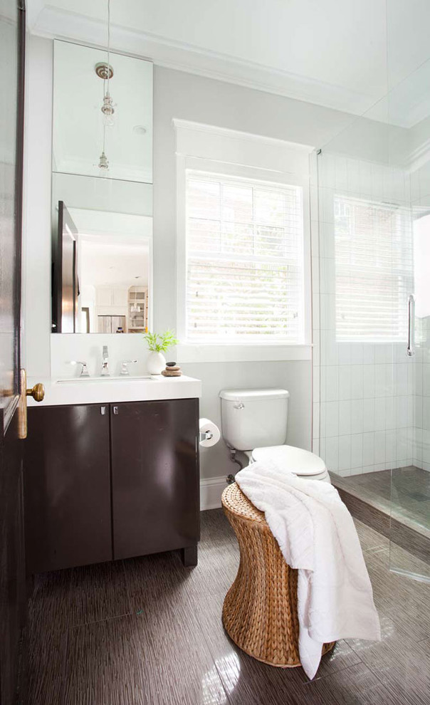 This is an example of a medium sized contemporary shower room bathroom in Atlanta with flat-panel cabinets, dark wood cabinets, an alcove shower, a submerged sink, solid surface worktops, a two-piece toilet, brown tiles, grey walls and brown floors.