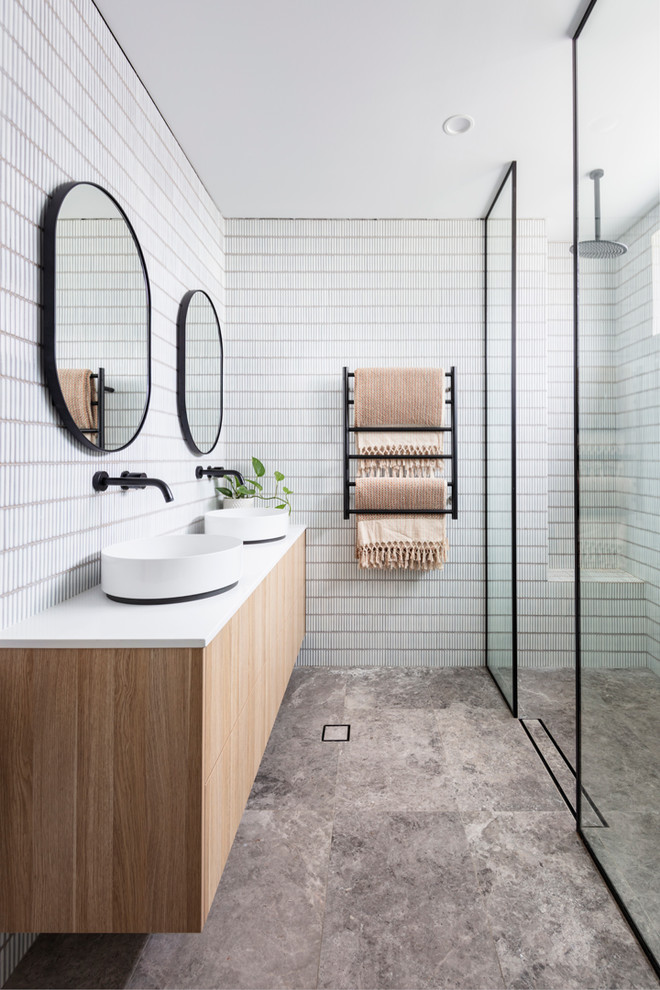 Стильный дизайн: ванная комната в скандинавском стиле с плоскими фасадами, светлыми деревянными фасадами, душем без бортиков, белой плиткой, душевой кабиной, настольной раковиной, серым полом, открытым душем и белой столешницей - последний тренд