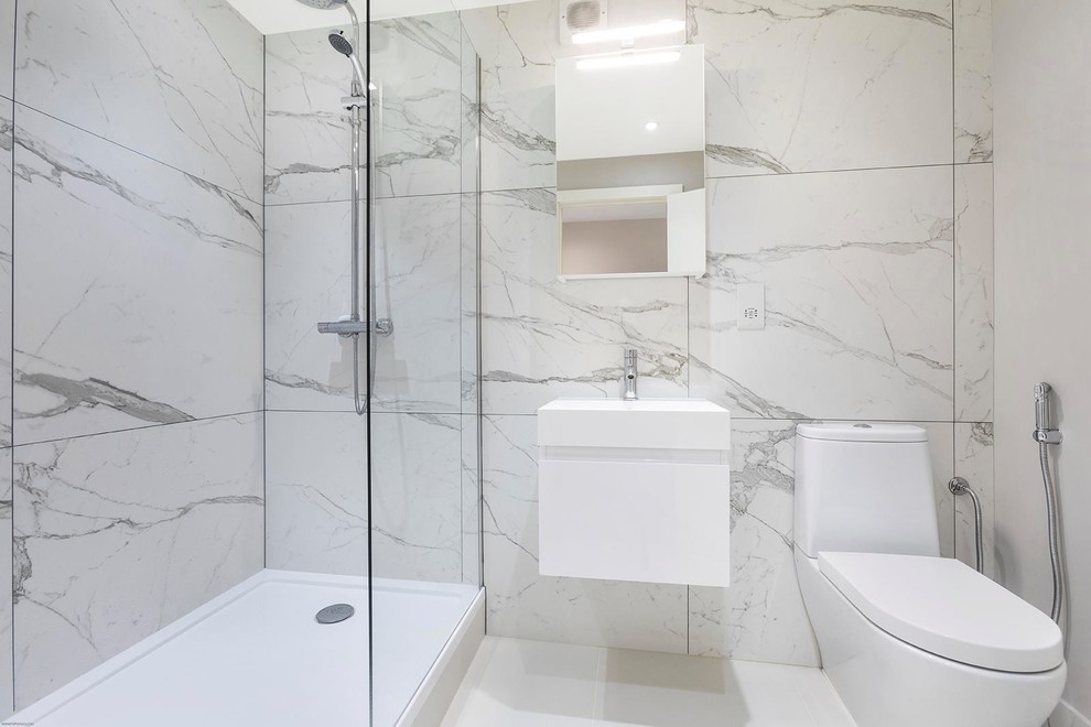 Foto på ett litet funkis badrum med dusch, med släta luckor, en öppen dusch, en toalettstol med hel cisternkåpa, marmorkakel, klinkergolv i porslin, ett integrerad handfat, beiget golv och med dusch som är öppen