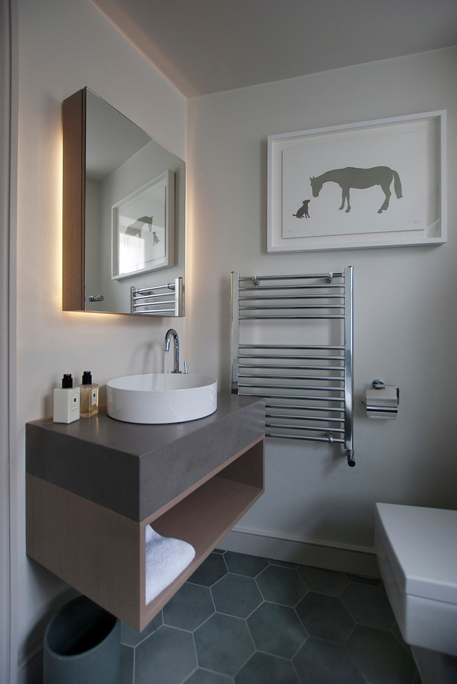 Diseño de cuarto de baño actual con armarios con paneles lisos, baldosas y/o azulejos grises, baldosas y/o azulejos de cerámica, paredes grises, suelo de azulejos de cemento y suelo gris