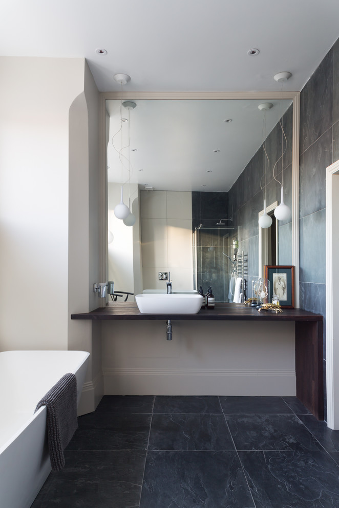 Skandinavisches Badezimmer mit freistehender Badewanne, weißer Wandfarbe, Aufsatzwaschbecken und Waschtisch aus Holz in London