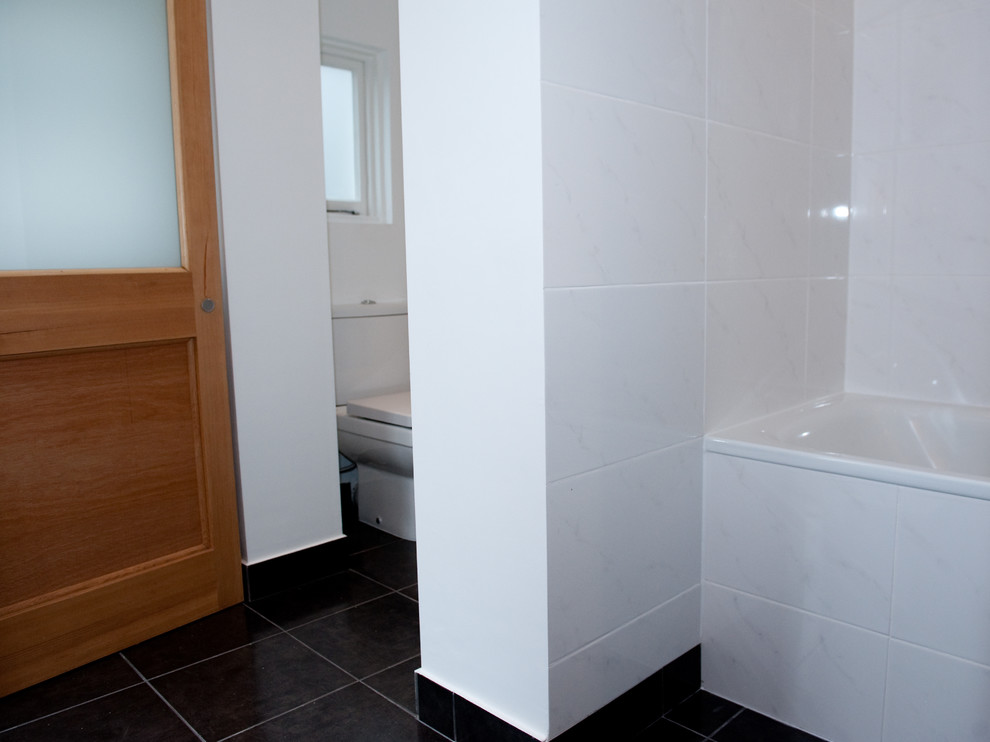 Example of a small classic kids' white tile and ceramic tile ceramic tile bathroom design in London with flat-panel cabinets, white cabinets, a one-piece toilet, white walls and a pedestal sink