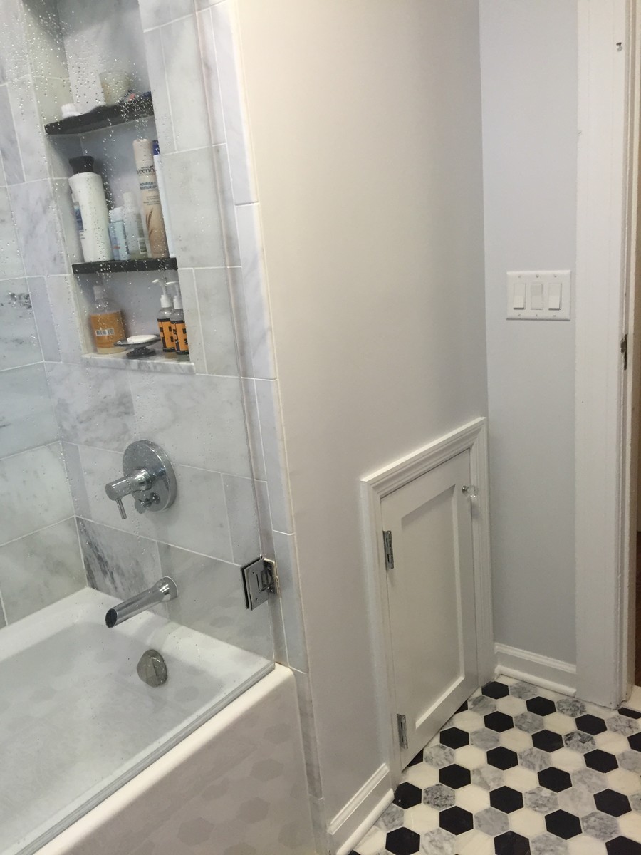 Example of a small trendy gray tile and marble tile ceramic tile and multicolored floor bathroom design in New York with shaker cabinets, black cabinets, a one-piece toilet, gray walls, an integrated sink, quartzite countertops and a hinged shower door