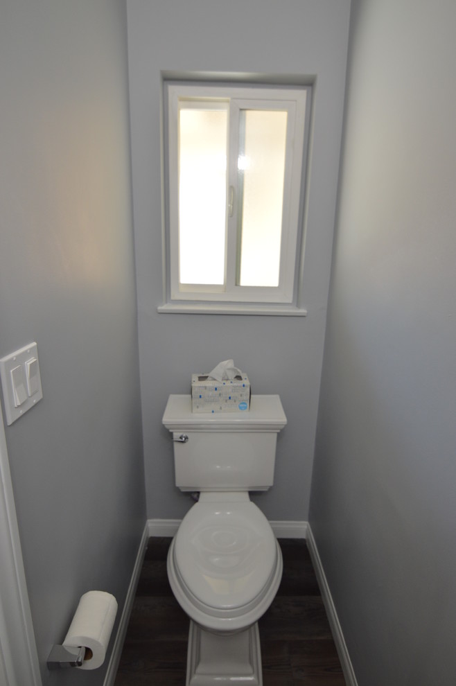 Inredning av ett modernt litet toalett, med en toalettstol med separat cisternkåpa, grå väggar, vinylgolv, ett piedestal handfat och flerfärgat golv