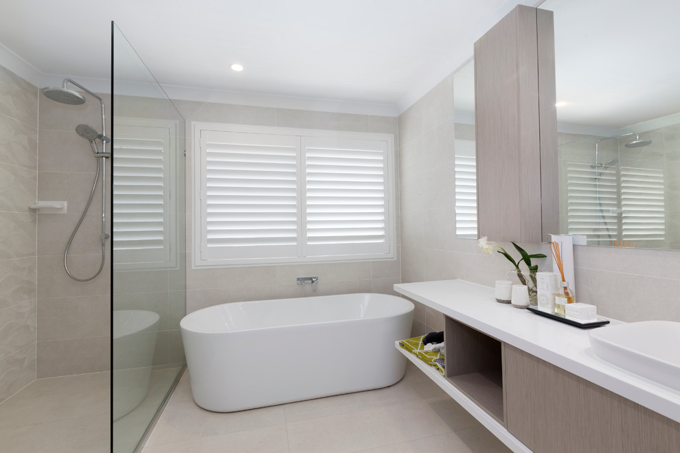 Идея дизайна: ванная комната в современном стиле с светлыми деревянными фасадами, отдельно стоящей ванной и столешницей из искусственного кварца
