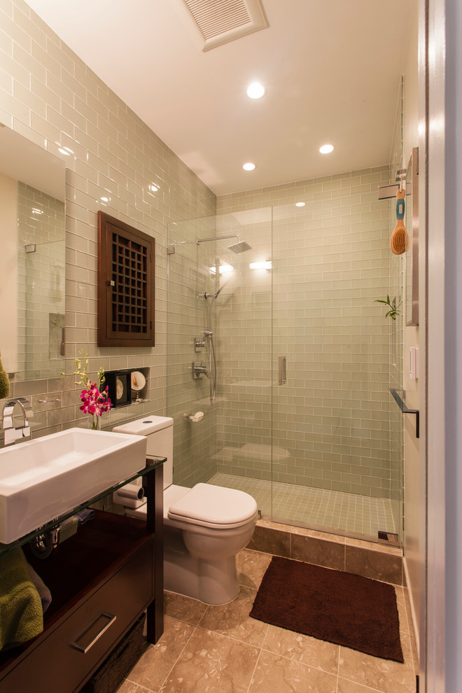 Exempel på ett modernt badrum, med ett fristående handfat, bänkskiva i glas, en toalettstol med separat cisternkåpa, beige kakel och gröna väggar