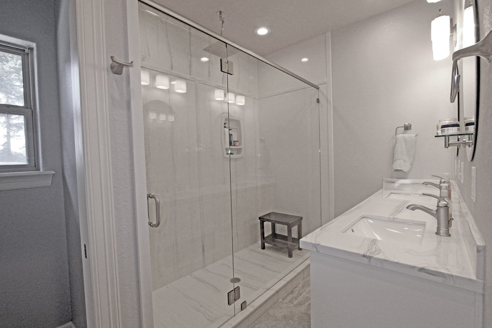 Inspiration för ett mellanstort funkis grå grått en-suite badrum, med skåp i shakerstil, vita skåp, en dubbeldusch, en toalettstol med separat cisternkåpa, grå väggar, klinkergolv i porslin, ett undermonterad handfat, bänkskiva i akrylsten, grått golv och dusch med gångjärnsdörr