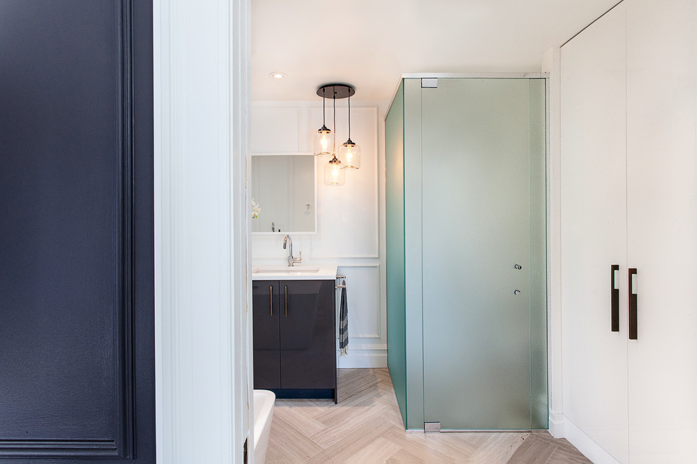 Large contemporary ensuite bathroom in Ottawa with a submerged sink, flat-panel cabinets, solid surface worktops, a freestanding bath, white walls, dark wood cabinets, a corner shower, light hardwood flooring and a hinged door.