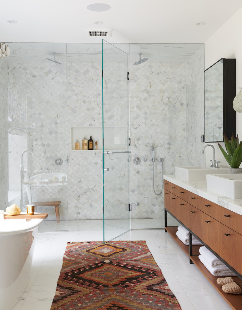 Идея дизайна: главная ванная комната в современном стиле с плоскими фасадами, фасадами цвета дерева среднего тона, отдельно стоящей ванной, серой плиткой, разноцветной плиткой, белой плиткой, белыми стенами, настольной раковиной, белым полом, душем с распашными дверями, разноцветной столешницей и двойным душем