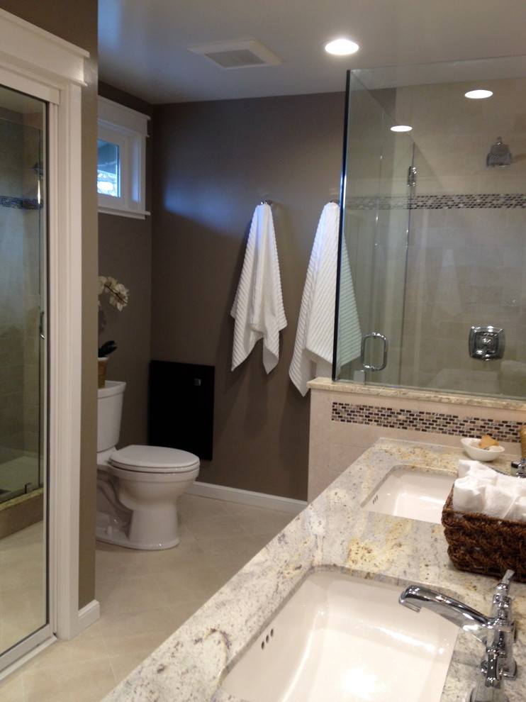 Foto på ett amerikanskt en-suite badrum, med ett undermonterad handfat, en hörndusch, en toalettstol med separat cisternkåpa, skåp i shakerstil, skåp i mörkt trä, granitbänkskiva, beige kakel, mosaik, grå väggar och klinkergolv i porslin