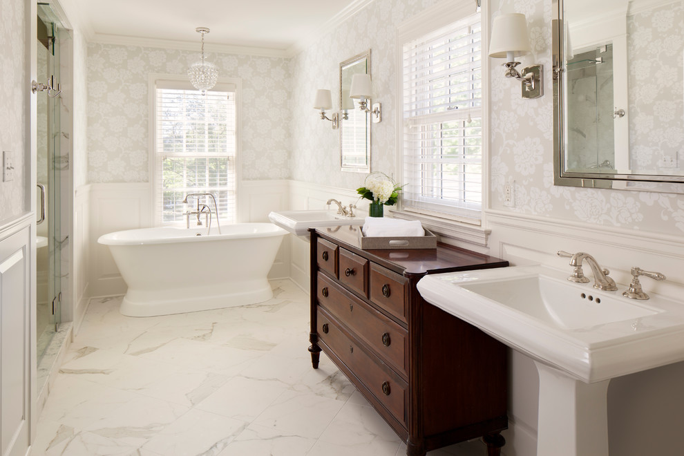 Идея дизайна: ванная комната в классическом стиле с раковиной с пьедесталом, фасадами с выступающей филенкой, темными деревянными фасадами, отдельно стоящей ванной и белыми стенами