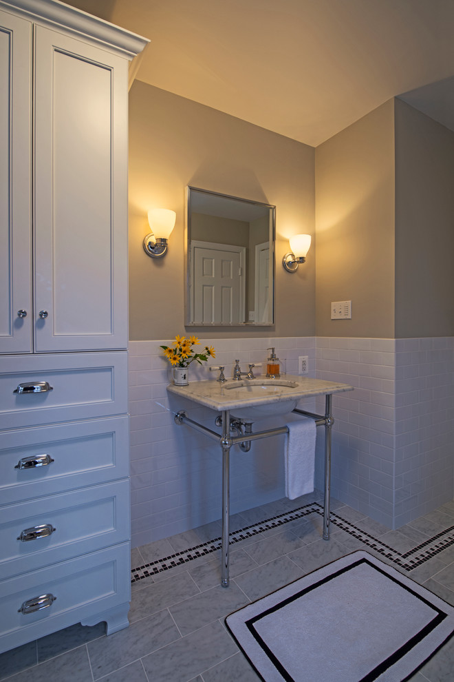 На фото: большая главная ванная комната в классическом стиле с консольной раковиной, мраморной столешницей, отдельно стоящей ванной, душем в нише, белой плиткой, каменной плиткой, бежевыми стенами и мраморным полом