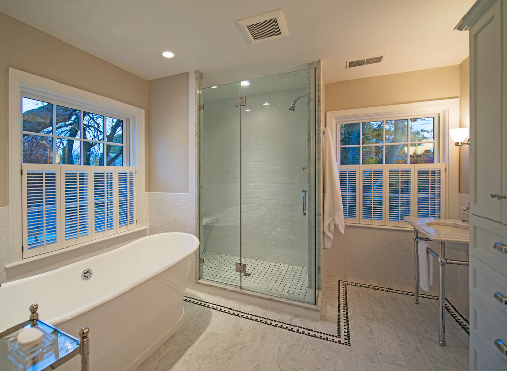 Inspiration för stora klassiska en-suite badrum, med ett konsol handfat, marmorbänkskiva, ett fristående badkar, en dusch i en alkov, vit kakel, stenkakel, beige väggar och marmorgolv