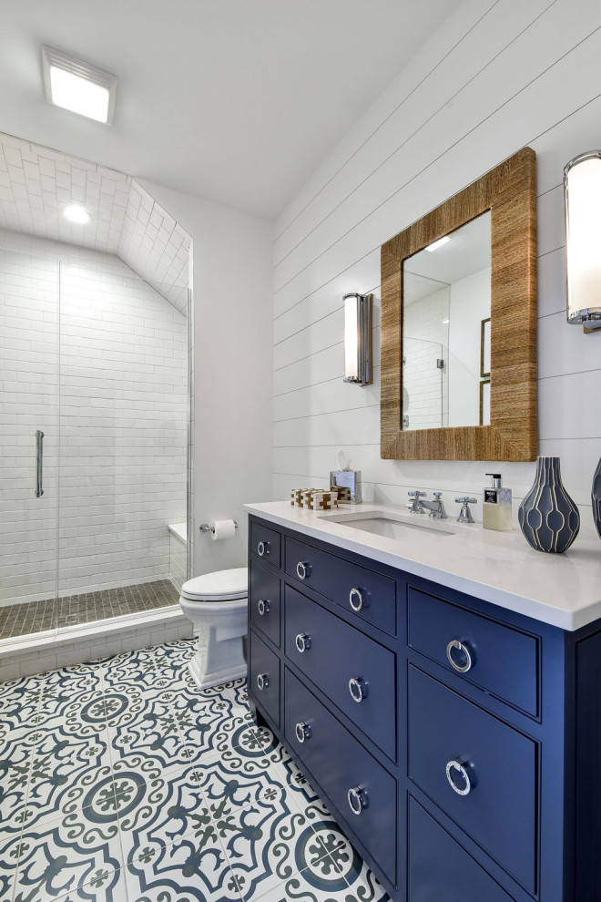 シカゴにある中くらいなトランジショナルスタイルのおしゃれな浴室 (インセット扉のキャビネット、青いキャビネット、アルコーブ型シャワー、一体型トイレ	、白いタイル、セラミックタイル、白い壁、セメントタイルの床、アンダーカウンター洗面器、クオーツストーンの洗面台、青い床、開き戸のシャワー、白い洗面カウンター、シャワーベンチ、洗面台1つ、造り付け洗面台、塗装板張りの壁) の写真