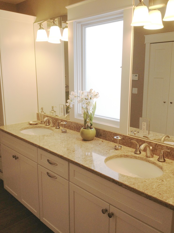 Example of a mid-sized transitional master beige tile and travertine tile dark wood floor and brown floor bathroom design in Detroit with an undermount sink, shaker cabinets, white cabinets, a one-piece toilet, beige walls, granite countertops and a hinged shower door