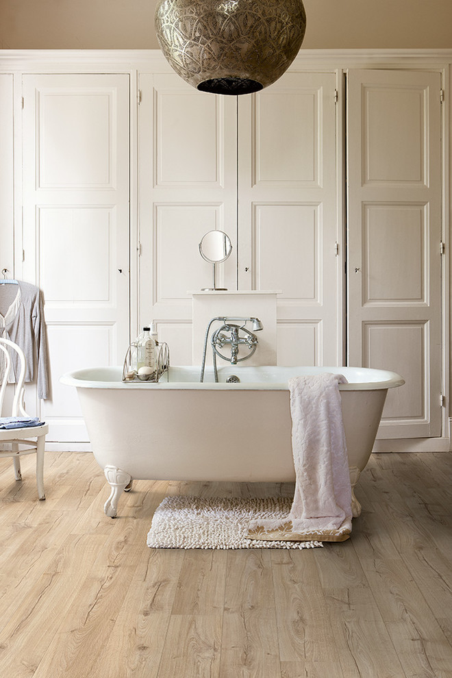 Ispirazione per una stanza da bagno padronale rustica di medie dimensioni con pavimento beige, vasca con piedi a zampa di leone, pareti beige e pavimento in laminato