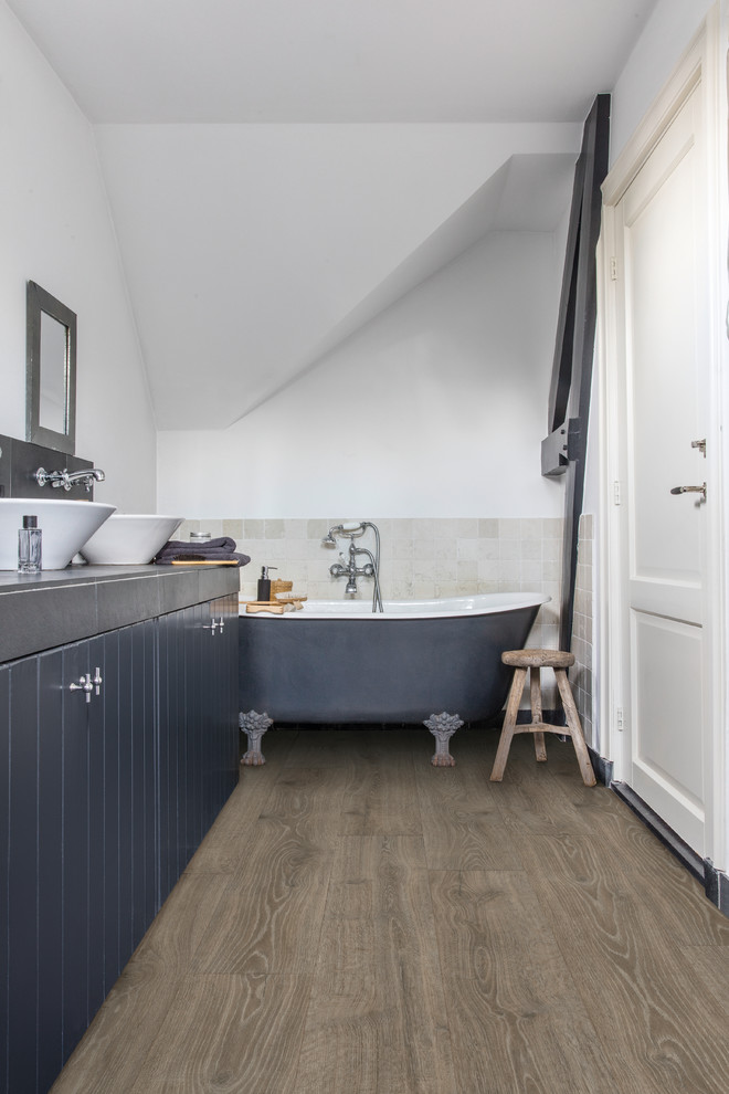 Mittelgroßes Rustikales Badezimmer En Suite mit Löwenfuß-Badewanne, weißer Wandfarbe, Laminat und braunem Boden in Sonstige