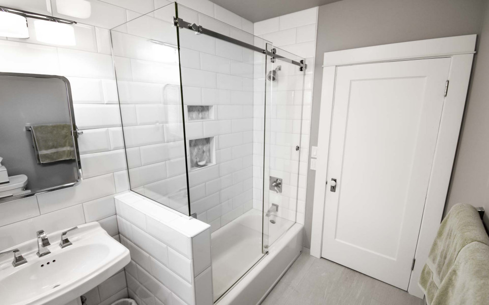 Пример оригинального дизайна: маленькая главная ванная комната в стиле неоклассика (современная классика) с ванной в нише, душем над ванной, раздельным унитазом, белой плиткой, плиткой кабанчик, белыми стенами, полом из керамической плитки, раковиной с пьедесталом, столешницей из дерева, серым полом, душем с раздвижными дверями, белой столешницей, нишей и тумбой под одну раковину для на участке и в саду