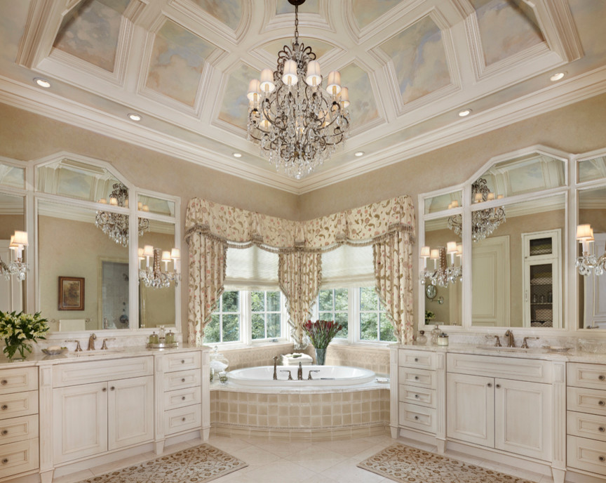 Klassisk inredning av ett stort en-suite badrum, med ett hörnbadkar, luckor med infälld panel, vita skåp, beige kakel, keramikplattor, beige väggar, klinkergolv i keramik, ett undermonterad handfat och marmorbänkskiva