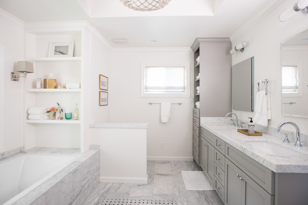 Источник вдохновения для домашнего уюта: ванная комната в стиле неоклассика (современная классика) с фасадами в стиле шейкер, серыми фасадами, полновстраиваемой ванной, белыми стенами, врезной раковиной, серым полом и белой столешницей