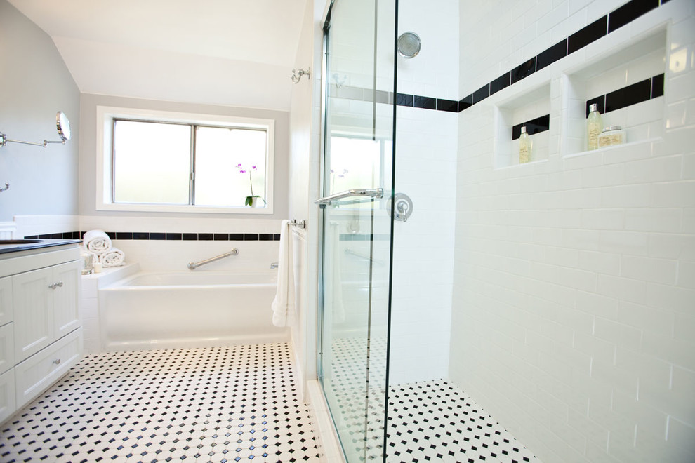 Modelo de cuarto de baño clásico con lavabo bajoencimera, puertas de armario blancas, bañera encastrada, ducha empotrada, baldosas y/o azulejos blancos, baldosas y/o azulejos de cemento, paredes grises y armarios con paneles empotrados