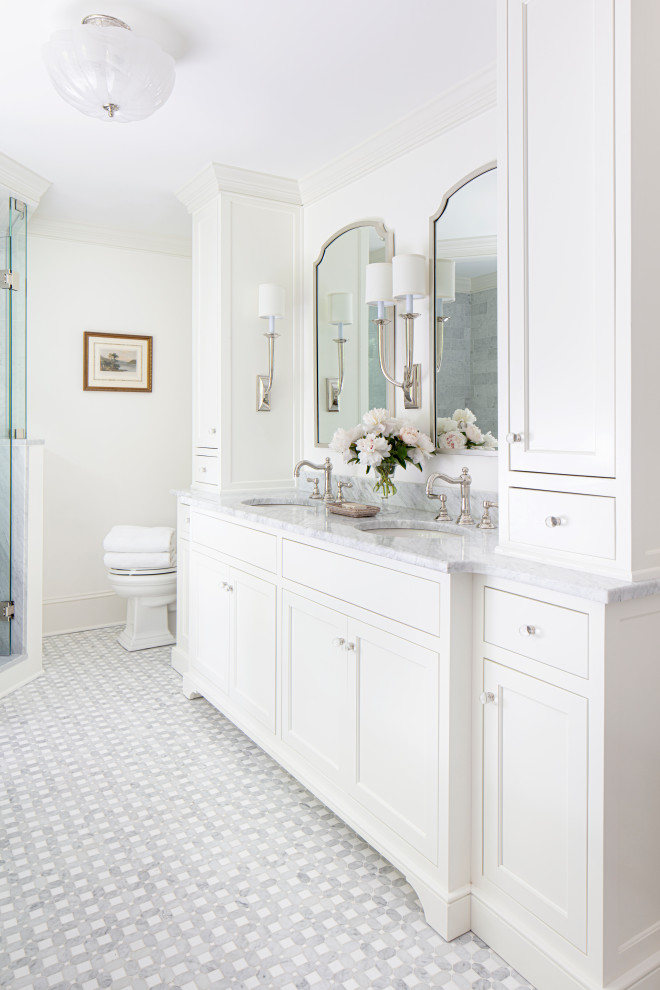 Стильный дизайн: главная ванная комната среднего размера в классическом стиле с фасадами островного типа, белыми фасадами, отдельно стоящей ванной, угловым душем, раздельным унитазом, серой плиткой, мраморной плиткой, белыми стенами, мраморным полом, врезной раковиной, мраморной столешницей, серым полом, душем с распашными дверями и белой столешницей - последний тренд
