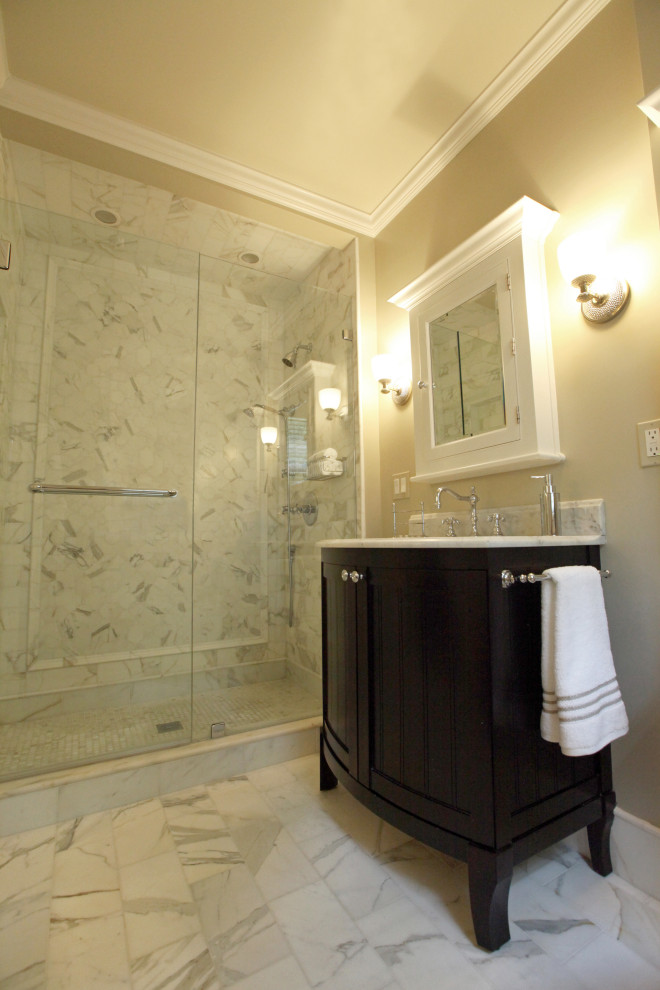 Medium sized classic ensuite bathroom in Boston with a two-piece toilet, white tiles, marble tiles, beige walls, a submerged sink, marble worktops, a hinged door, white worktops, freestanding cabinets, black cabinets, marble flooring, white floors, a single sink and a built in vanity unit.