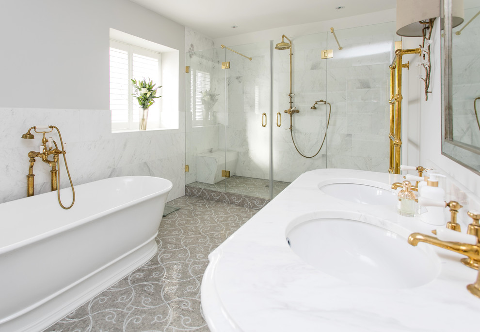 Design ideas for a large victorian ensuite bathroom in Surrey with shaker cabinets, grey cabinets, a freestanding bath, a walk-in shower, a wall mounted toilet, white tiles, stone tiles, grey walls, mosaic tile flooring, a built-in sink and marble worktops.