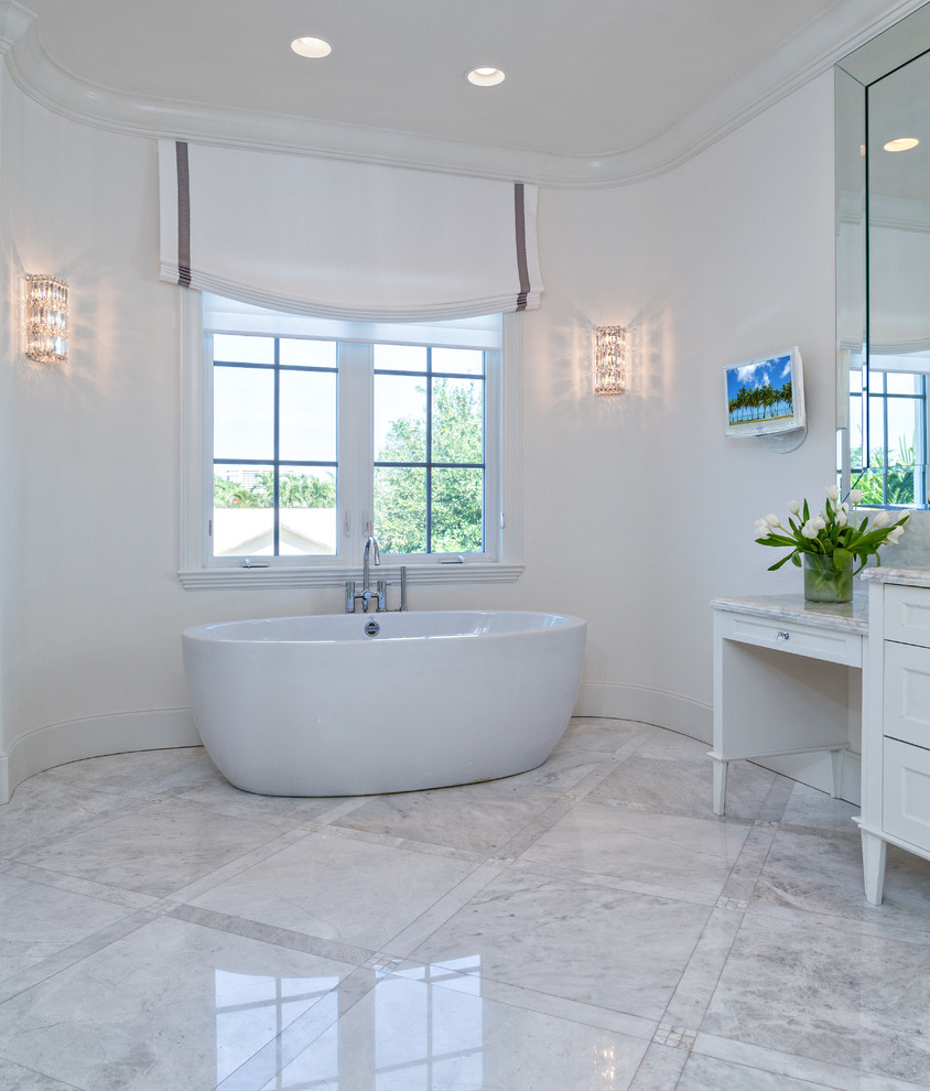 Пример оригинального дизайна: главная ванная комната среднего размера в стиле неоклассика (современная классика) с фасадами в стиле шейкер, белыми фасадами, отдельно стоящей ванной, серой плиткой, плиткой из известняка, белыми стенами, мраморным полом и мраморной столешницей