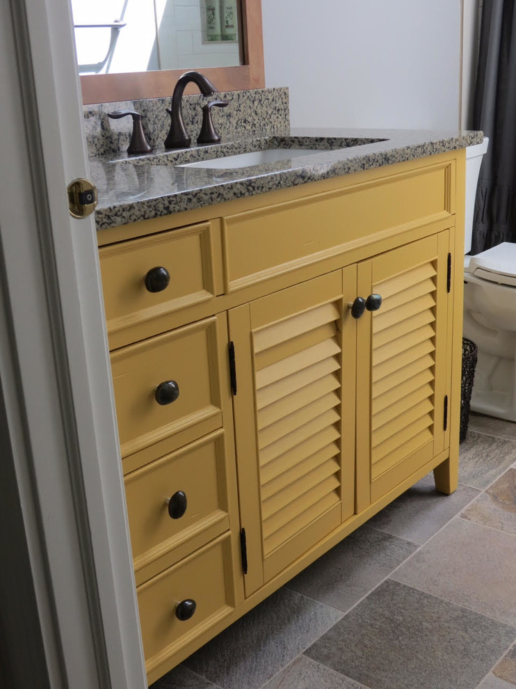 Пример оригинального дизайна: маленькая ванная комната в стиле неоклассика (современная классика) с фасадами с филенкой типа жалюзи, желтыми фасадами, душем в нише, раздельным унитазом, серыми стенами, полом из сланца, душевой кабиной, врезной раковиной, столешницей из гранита, разноцветным полом, шторкой для ванной и бежевой столешницей для на участке и в саду