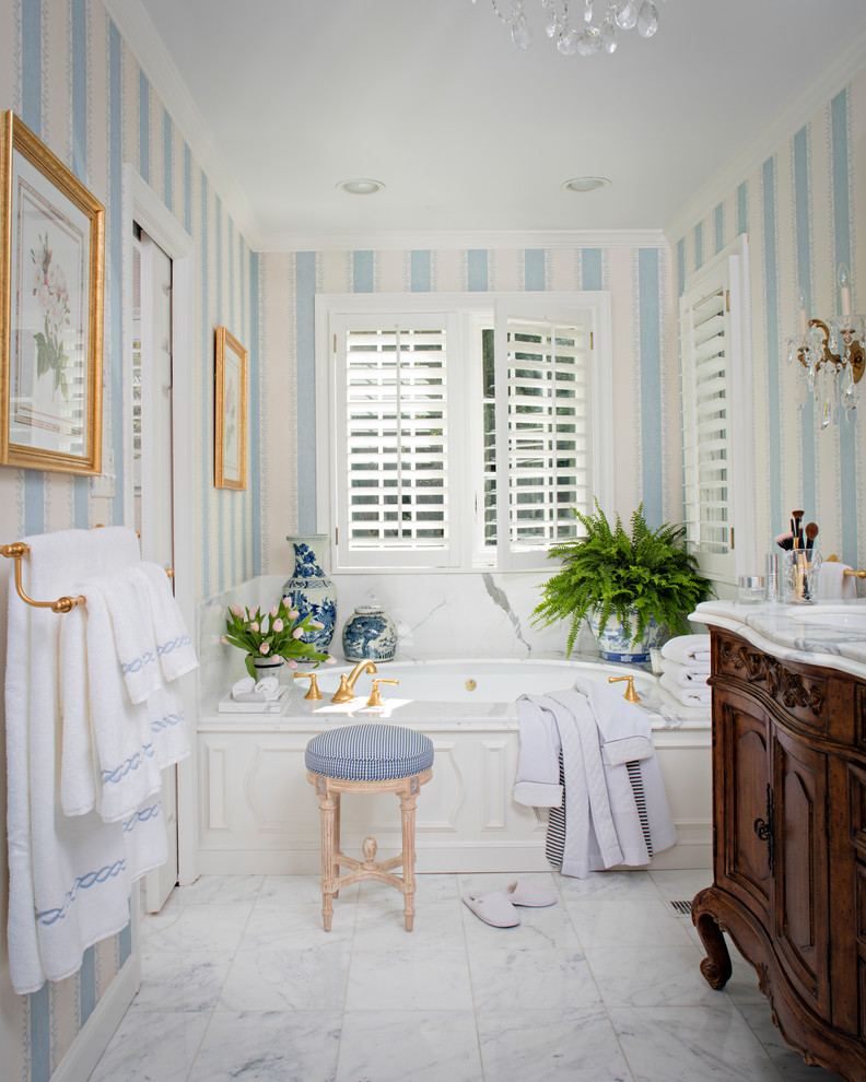 Inspiration pour une grande salle de bain principale traditionnelle en bois brun avec une baignoire posée, un carrelage blanc, un mur blanc, un sol en marbre, un lavabo encastré, un plan de toilette en marbre et un placard en trompe-l'oeil.